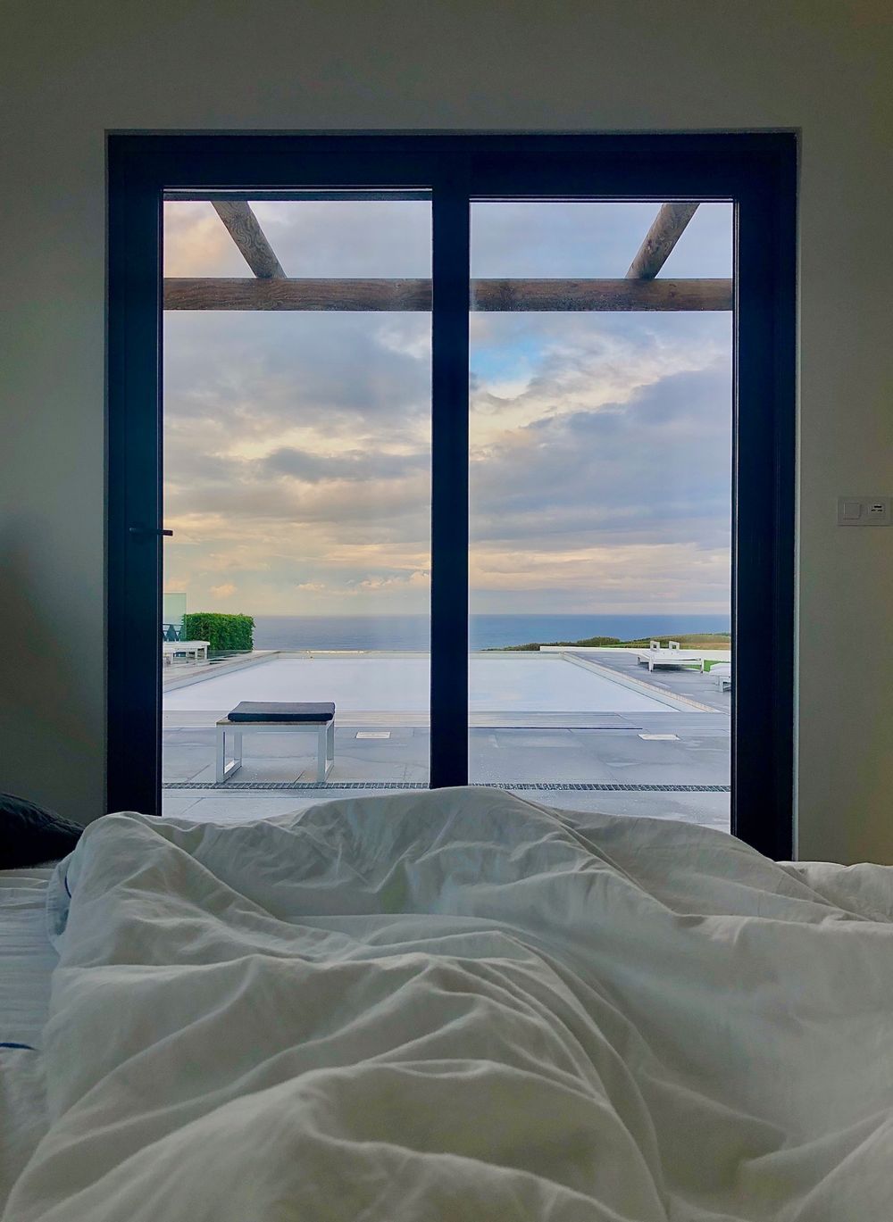 Maré room, with a view of the pool and the ocean from the bed